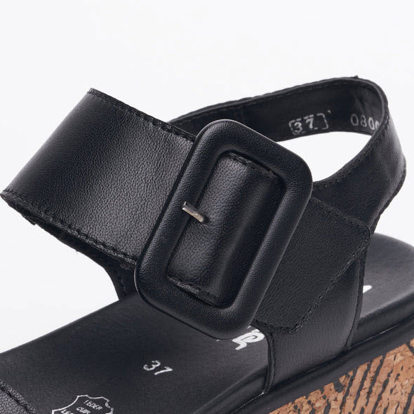 Close-up of a black leather Revolution sandal with a Velcro strap, showing size marking on the insole.