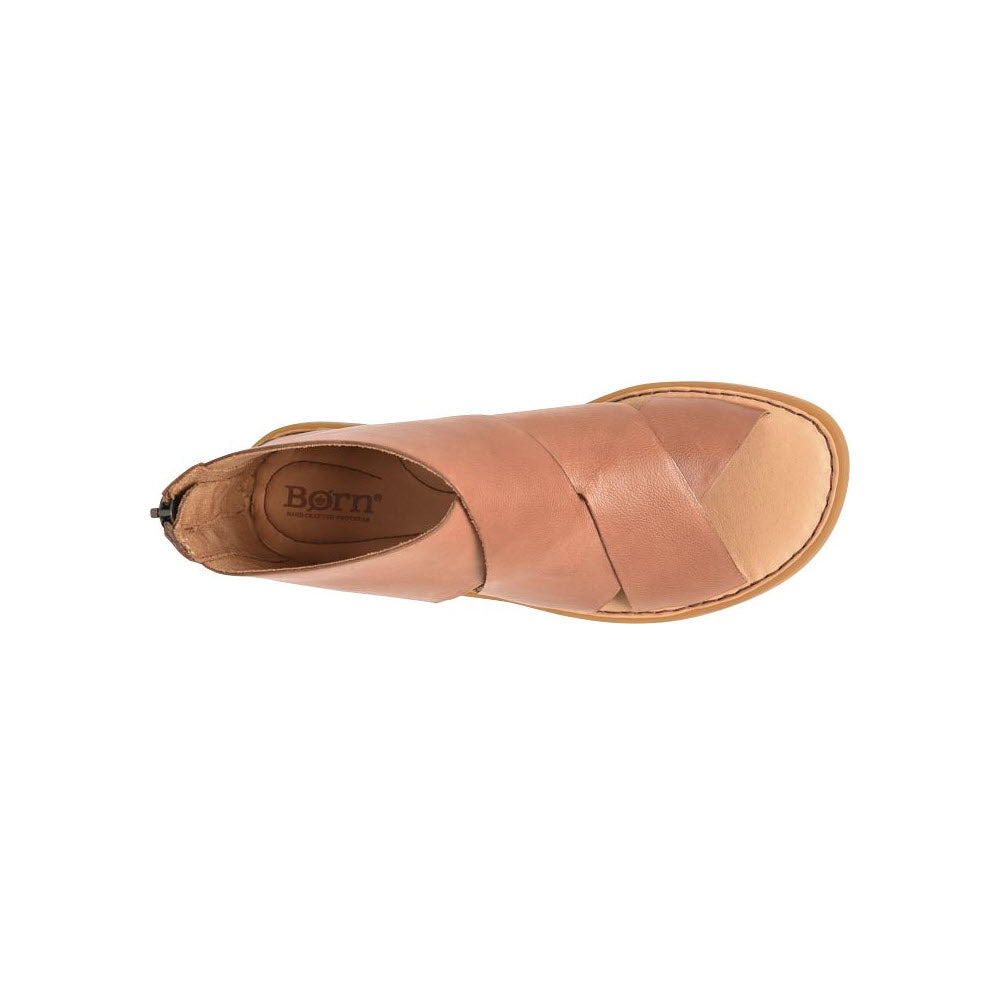 Top view of a single light brown ultra-soft leather slip-on shoe with a flat sole, showcasing a Born signature comfort logo inside.