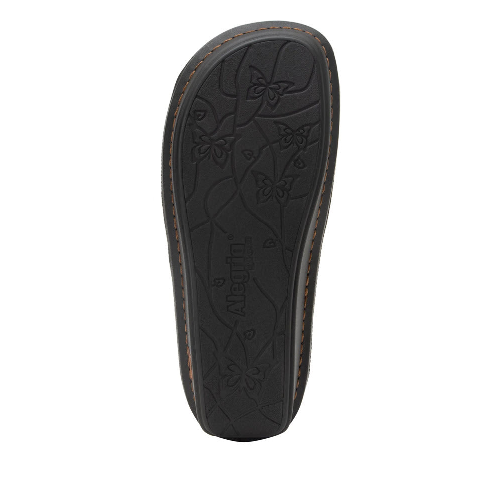 Sole of a ALEGRIA VALERIE COGNAC - WOMENS leather shoe displaying embossed floral designs and the brand name &#39;Alegria&#39;, enhanced with a memory foam footbed.