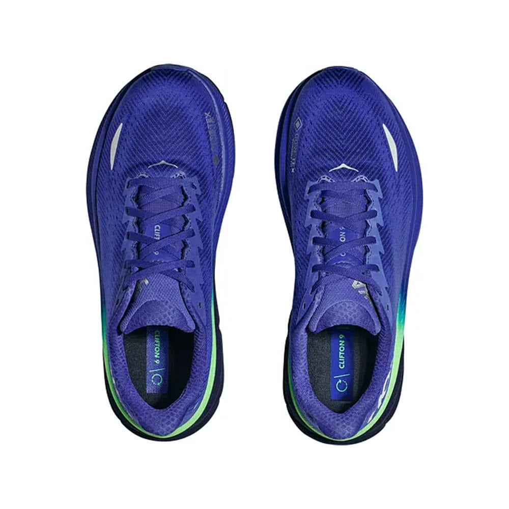 A pair of Hoka Clifton 9 GTX Dazzling Blue/Evening Sky running shoes with green accents, viewed from above, showing the laces and interior branding.