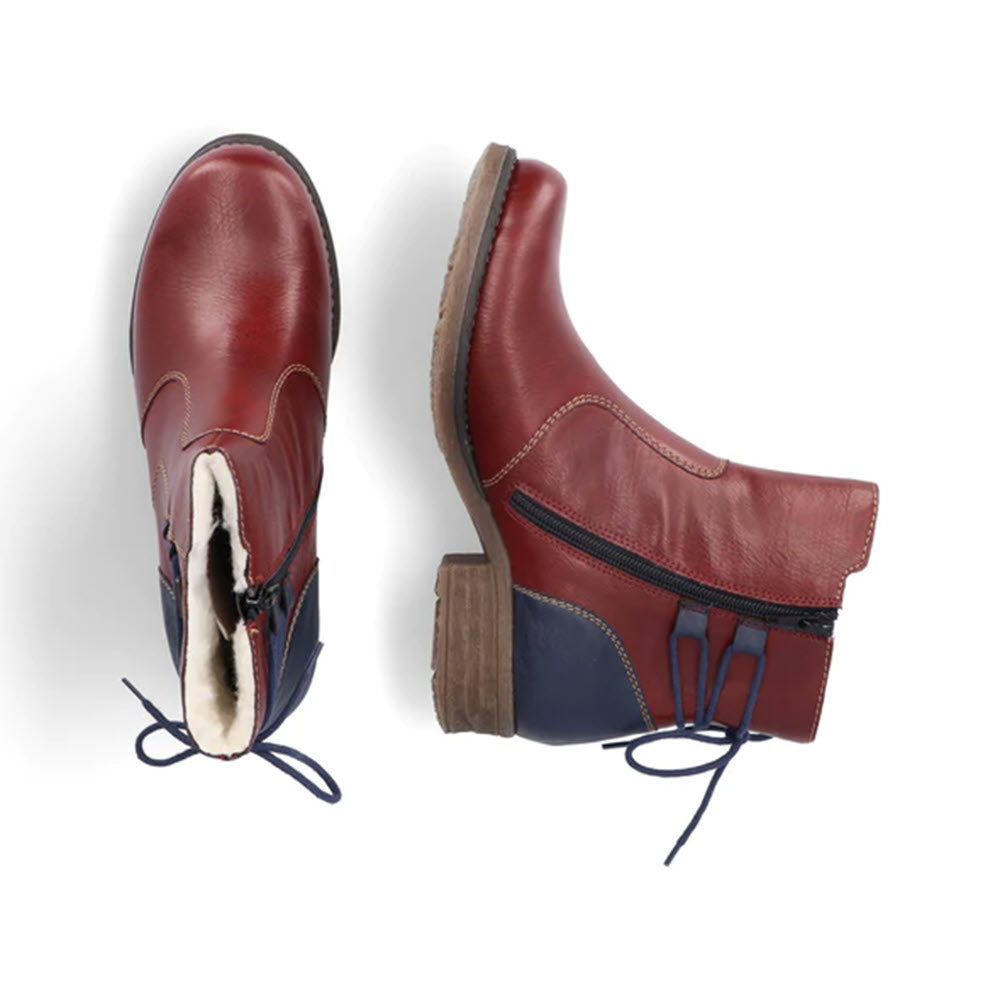 Two stylish Rieker ankle booties with tie back, one standing upright and the other lying on its side, featuring red leather and blue accents, isolated on a white background.