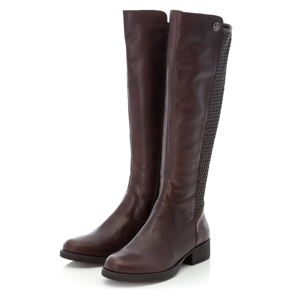A pair of tall brown leather riding boots, RIEKER FAITH 91 CHOCOLATE - WOMENS, with a decorative side zipper, standing upright against a white background.