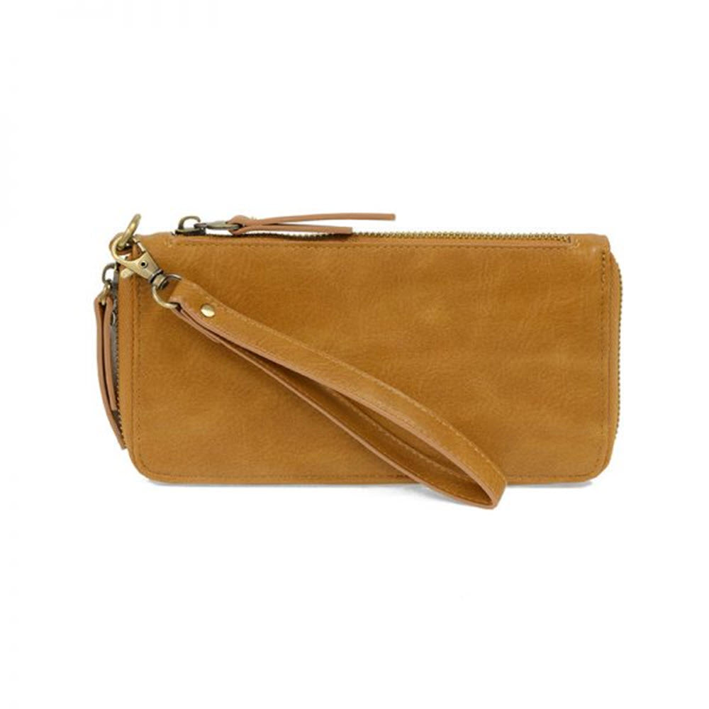 A tan Joy Susan Chloe Zip Around Wallet Almond clutch purse with a wrist strap and zipper closure, displayed on a white background.