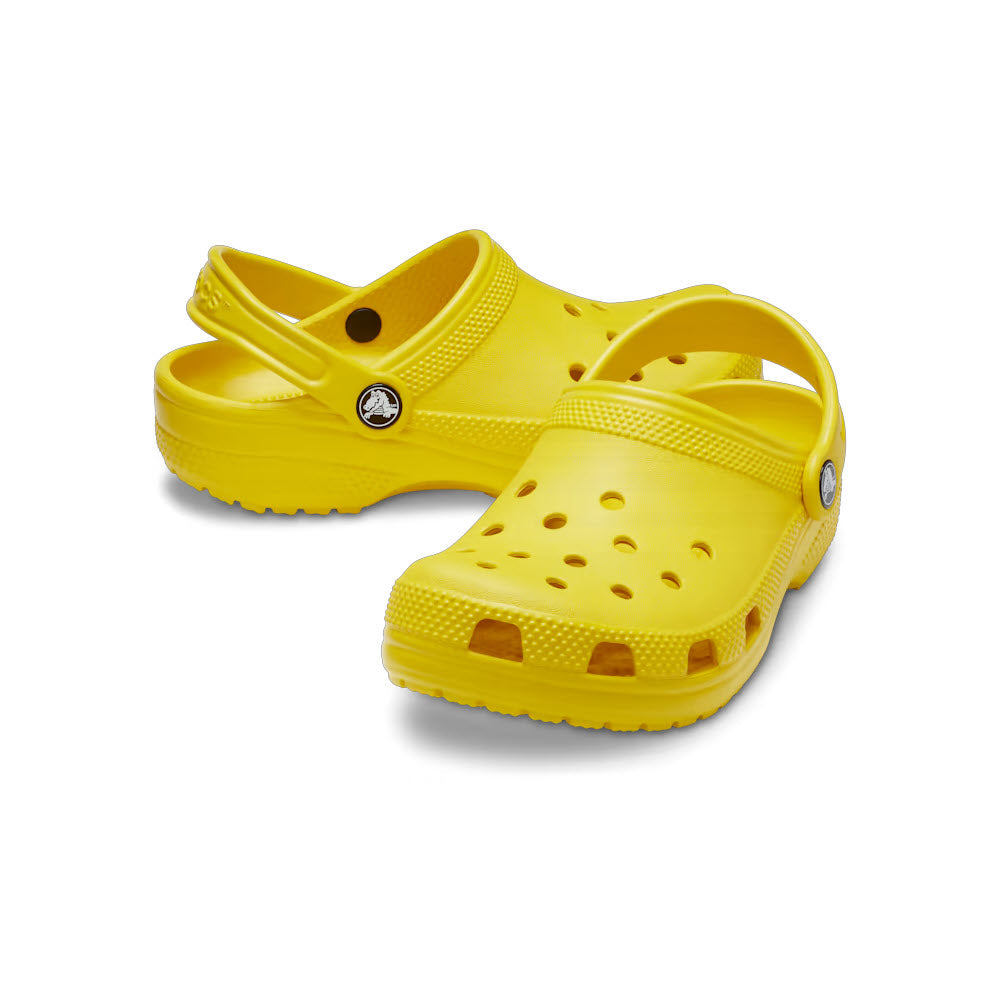 A pair of yellow Crocs Classic Clog Sunflower shoes with a non-slip outsole isolated on a white background.
