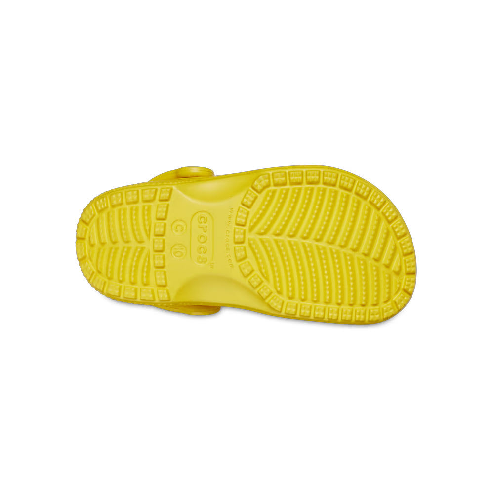 Bright yellow Crocs Classic Clog sole, crafted from Croslite™ foam, displaying a detailed tread pattern for enhanced grip.