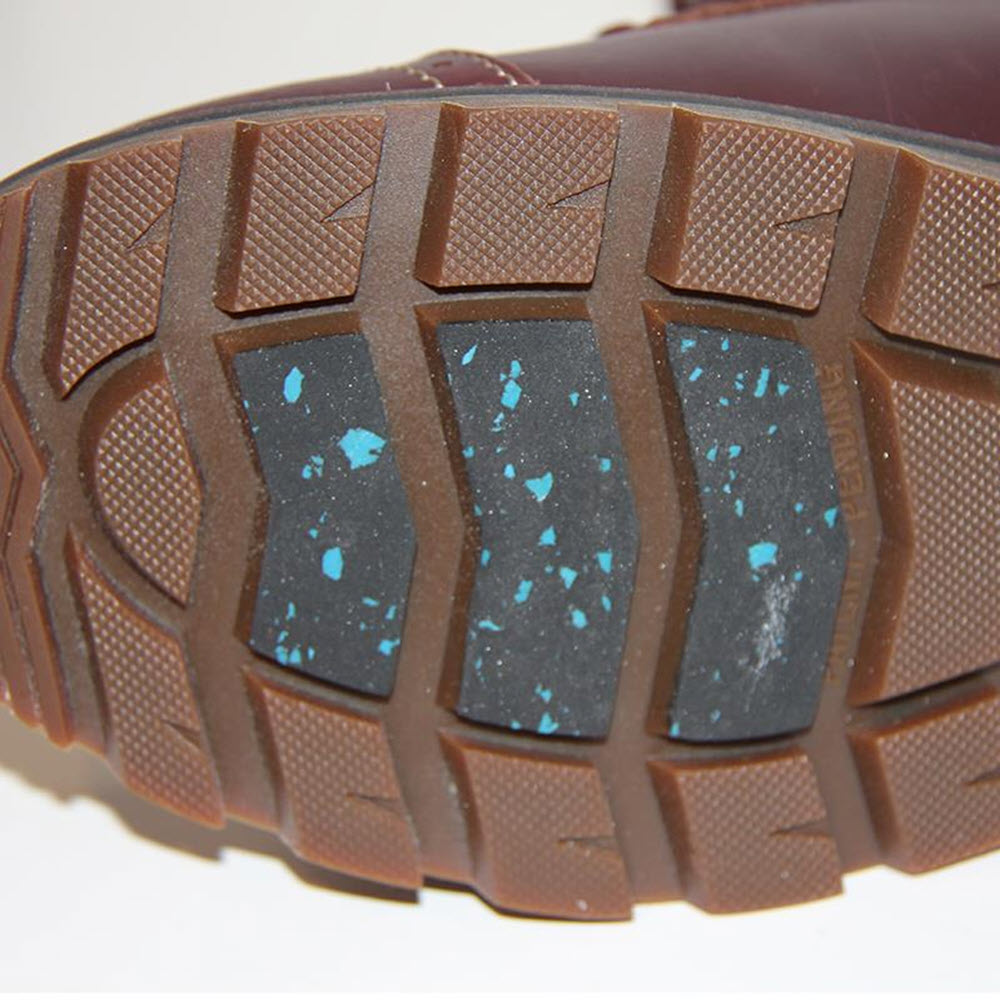 Close-up of a NexGrip Ice Stella Brown Repel - Womens boot sole with a speckled blue and black pattern on rectangular grips.