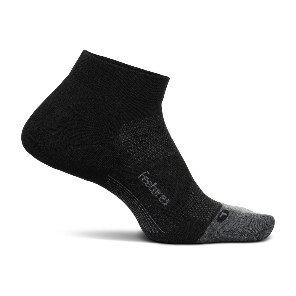A single Feetures Elite Max Low Cut sock in black displayed against a white background, featuring gray reinforcement on the heel and toe areas and Targeted Compression branded text on the side.