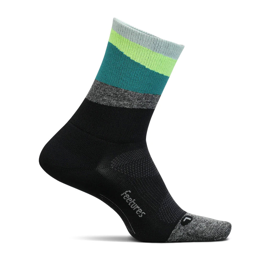 A single black sock with color-block design featuring green, blue, and gray at the top, labeled with the word "Feetures Elite Ultra Light Mini Crew Socks Accent Green - Mens" on the side.