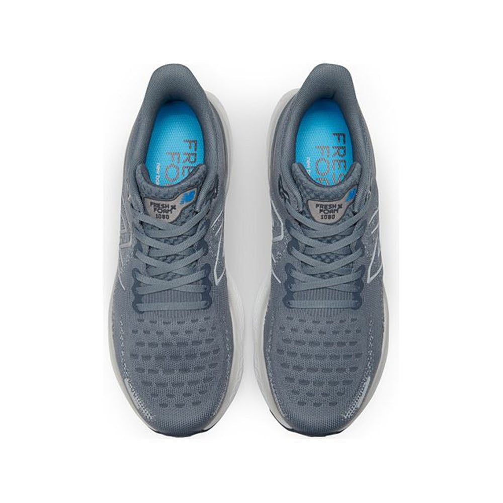 A pair of New Balance M1080V12 Steel/Serene - Mens sneakers with blue insoles, featuring engineered Hypoknit upper, displayed in a top-down view on a white background.