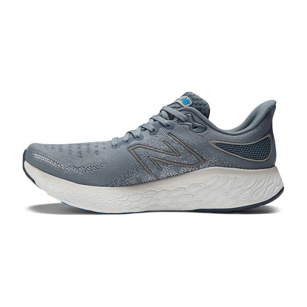 A New Balance M1080V12 Steel/Serene running shoe in gray and blue, featuring a prominent logo on the side, white midsole, and a blue outsole with pinnacle underfoot cushioning.