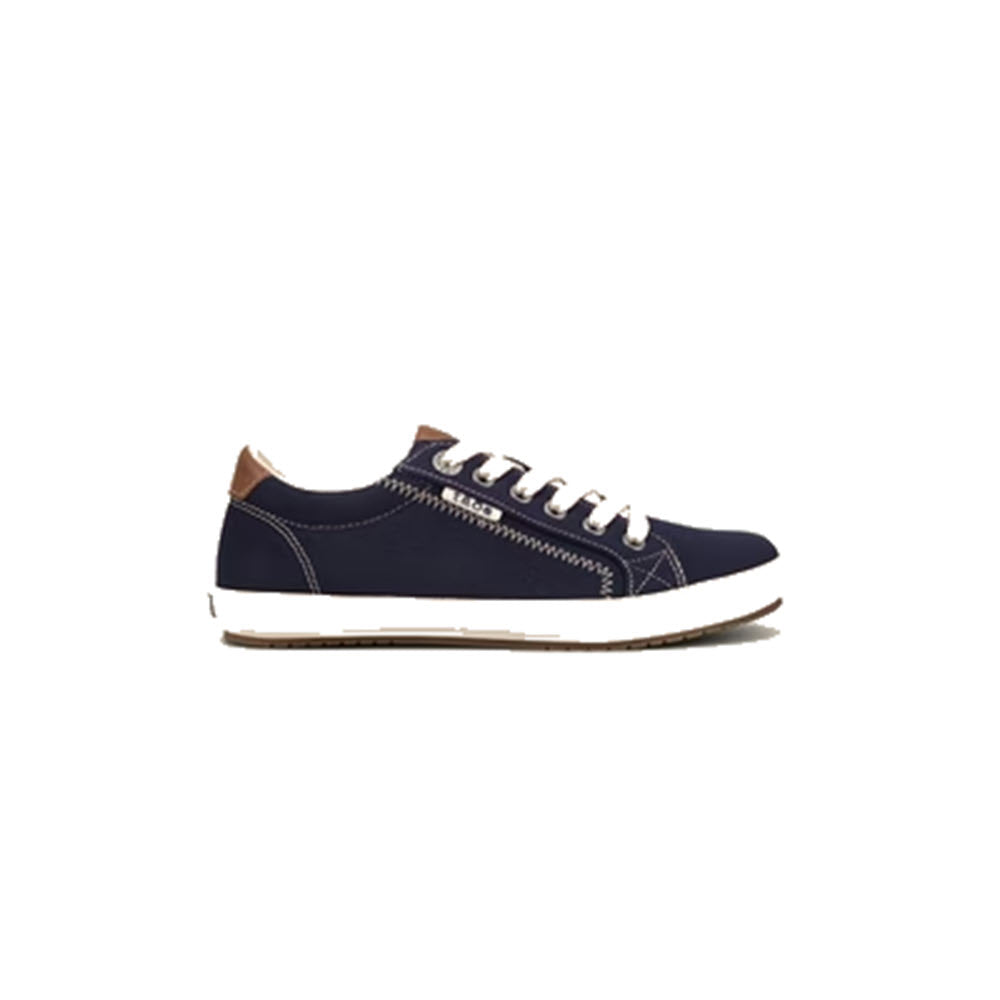 A Taos Star Burst Navy women&#39;s sneaker with white laces, tan heel accent, and a white sole, made from fabricated leather, isolated on a white background.