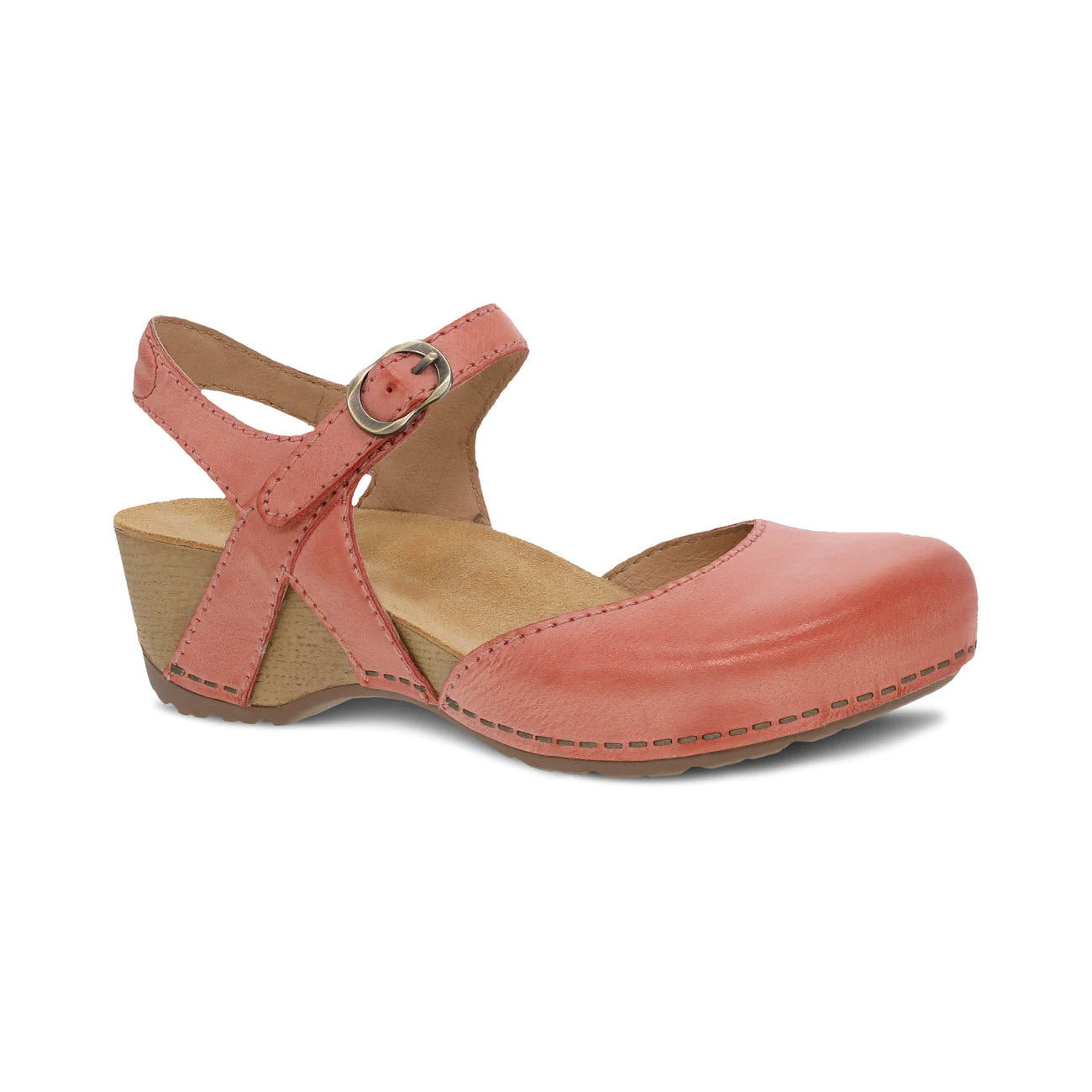 A Dansko coral pink leather sandal with a closed toe, an ankle strap, buckle closure, and a medium wood block heel.