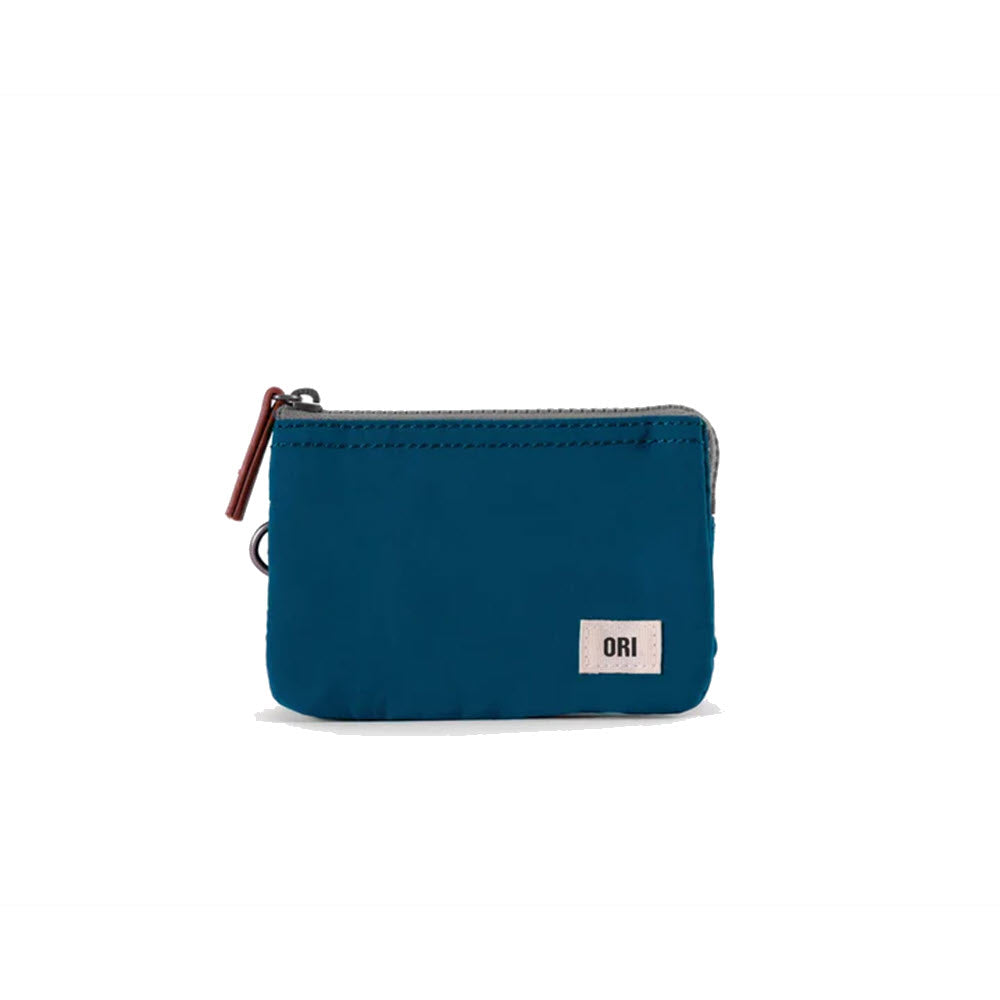 A small teal blue ORI London Carnaby zipper wallet with a white &quot;Ori London&quot; brand label on the side, displayed against a white background. This weather-resistant wallet is ideal for all conditions.