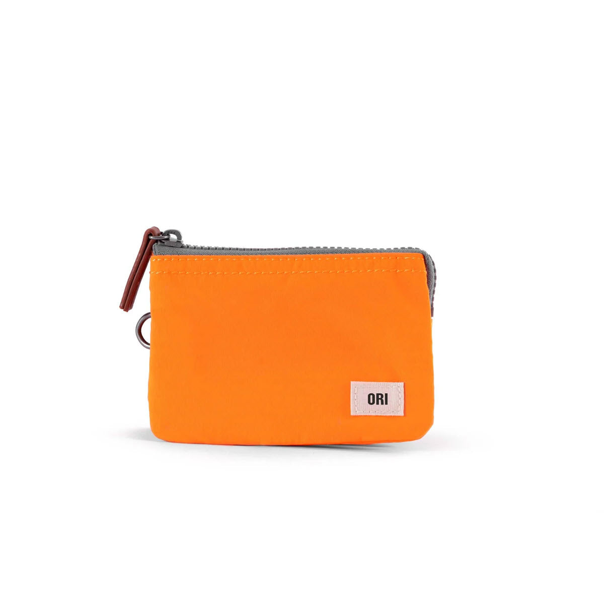 A small, orange Ori London Carnaby pouch with a black tag labeled "ori" on a white background.