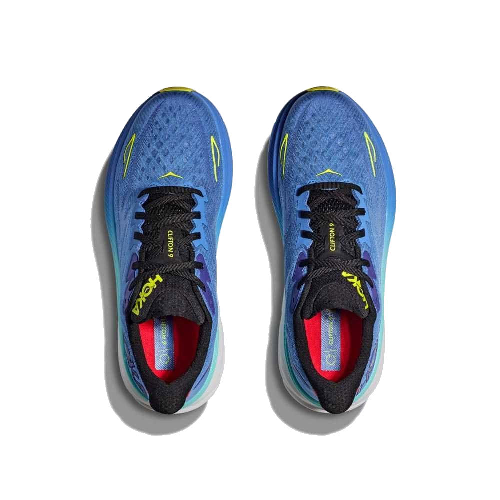 Top view of a pair of blue and yellow Hoka Clifton 9 running shoes with visible brand logos on the insoles, isolated on a white background.
