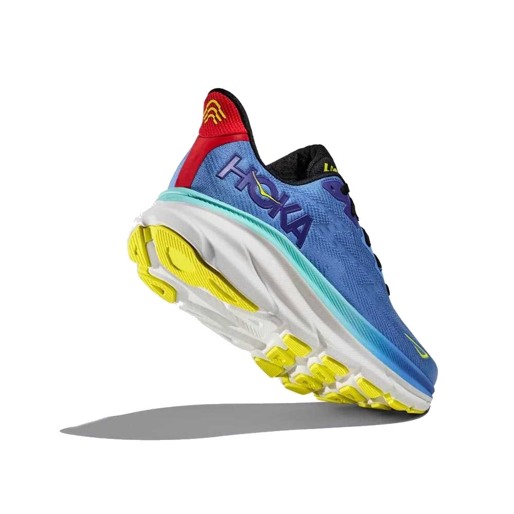 A Hoka CLIFTON 9 VIRTUAL BLUE/CERISE - MENS running shoe, featuring a multi-colored design with blue, red, and yellow highlights and a thick, cushioned sole with an improved outsole design.