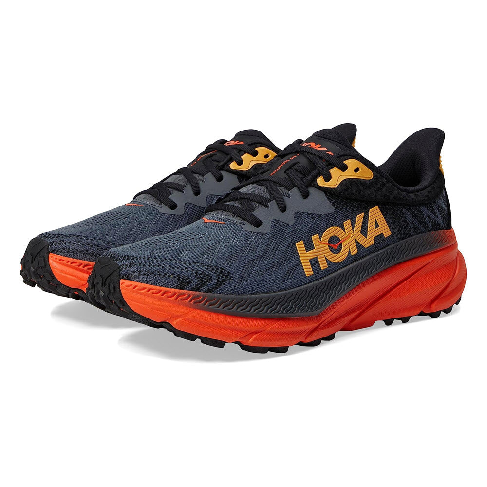 A pair of HOKA CHALLENGER ATR 7 trail running shoes with navy upper and orange soles, featuring prominent logo placement.