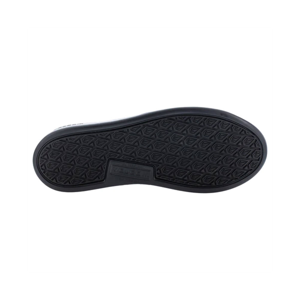 Black rubber sole of a slip-resistant wide-fit Volcom Chill Composite Toe Slip On Work Shoe Black - Mens displaying a diamond tread pattern and a rectangular Volcom brand label in the center.