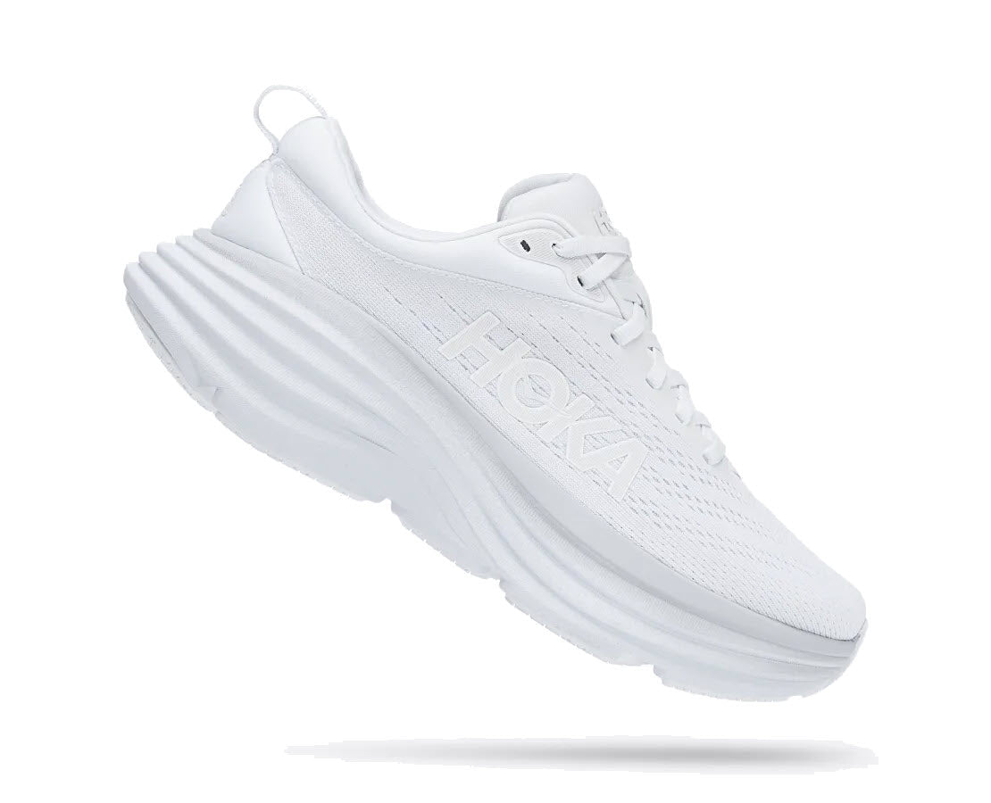 White HOKA Bondi 8 sneaker on a plain background displaying the Hoka brand name on the side and textured sole.
